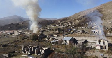 In this photo taken with a drone, smoke rises from houses burnt by Armenian residents as they leave the Armenian-occupied region of Nagorno-Karabakh, Azerbaijan, Nov. 14, 2020. (AP Photo)