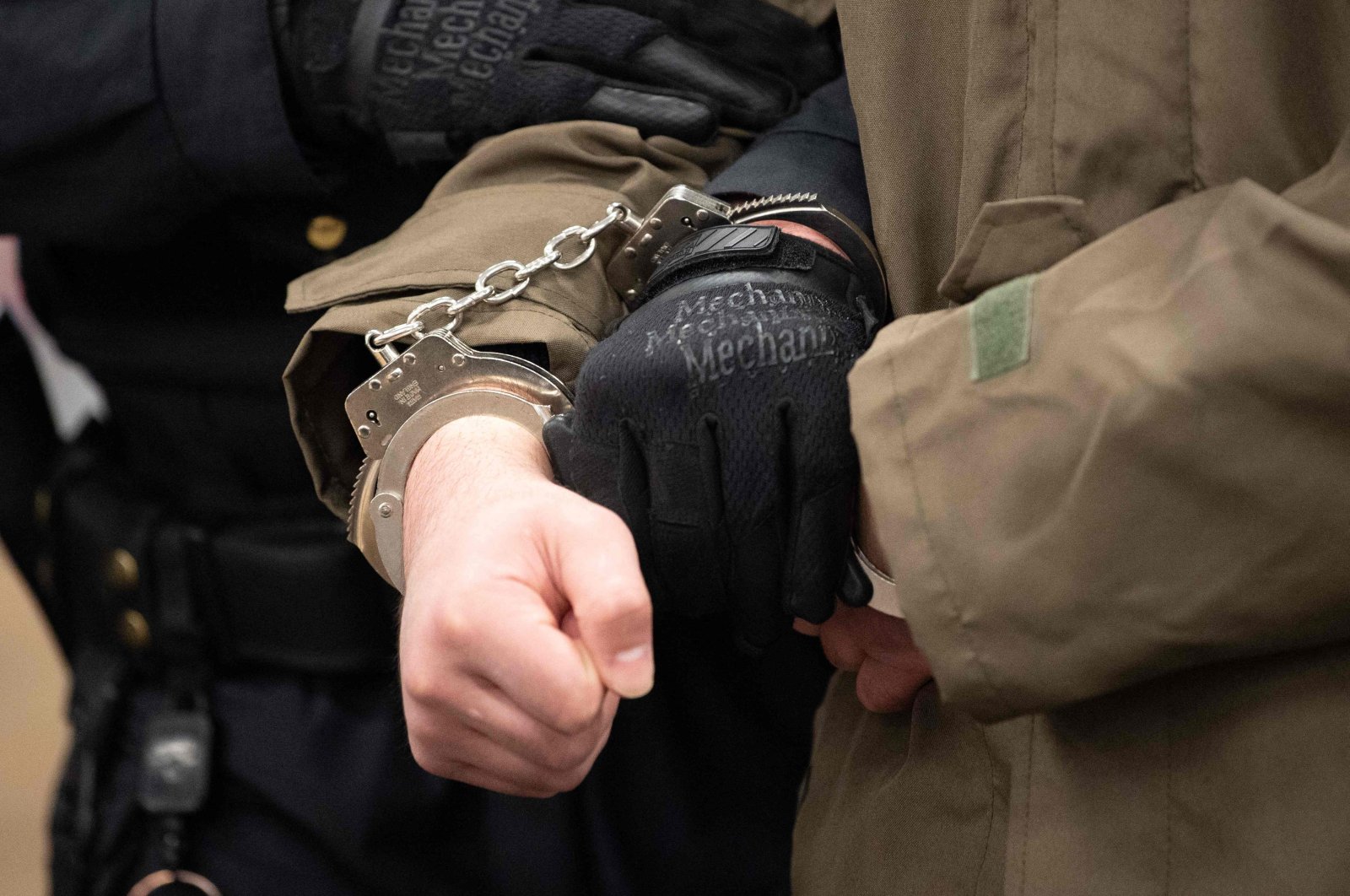 Handcuffed defendant Abdullah A (C), accused of stabbing a German tourist to death in Dresden, is led by court officials into the hearing room of his trial at the Higher Regional Court in Dresden, eastern Germany, April 12, 2021. (AFP Photo)