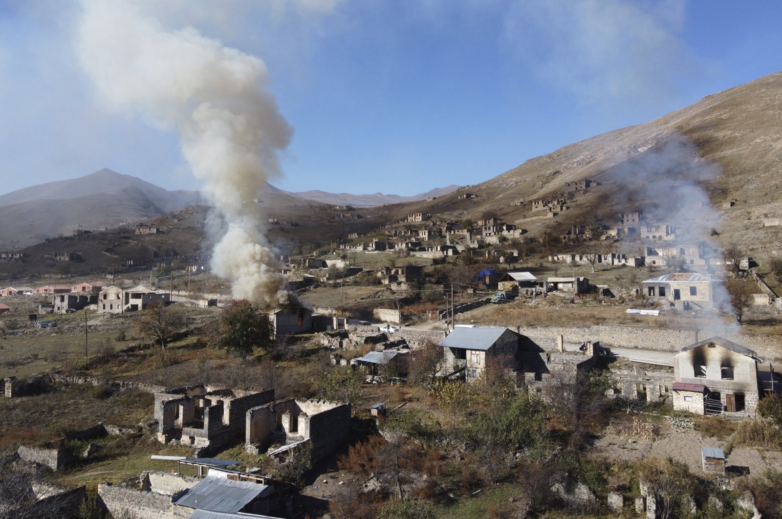 In this photo taken with a drone, smoke rises from houses burnt by Armenian residents as they leave the Armenian-occupied region of Nagorno-Karabakh, Azerbaijan, Nov. 14, 2020. (AP Photo)