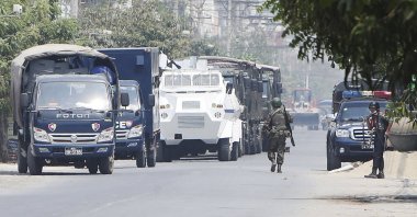 A soldier walks along a row of vehicles of security forces parked on a road in Mandalay, Myanmar, March 19, 2021. (AP Photos)