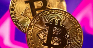 A representation of virtual currency Bitcoin is seen in front of a stock graph in this illustration taken March 15, 2021. (Reuters Photo)