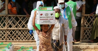 A girl carries an aid package donated by the Humanitarian Aid Foundation (IHH) at a refugee camp in Cox's Bazaar, Bangladesh, May 2, 2020. (COURTESY OF IHH)
