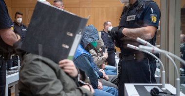 A defendant covers his face at the beginning of a trial against 11 Germans charged with belonging to a far-right organization, that prosecutors say aimed to attack mosques, at a higher regional court in Stuttgart, Germany, April 13, 2021. (Reuters Photo)