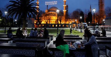 Muslims eat their iftar meals in front of Sultanahmet Mosque (Blue Mosque) in Istanbul, Turkey, April 13, 2021. (REUTERS PHOTO)