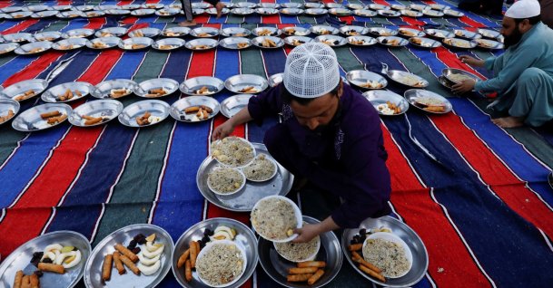 A man arranges plates of food for iftar during the fasting month of Ramadan, as the COVID-19 outbreak continues, at a mosque in Karachi, Pakistan, April 14, 2021. (Reuters Photo)