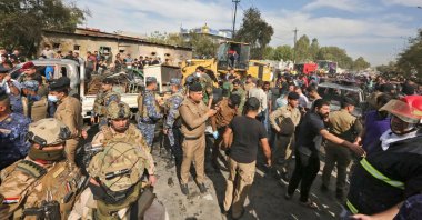 Members of the Iraqi army and security forces gather at the scene of an explosion in the Habibiya district of the Sadr City suburb of Iraq's capital Baghdad, April 15, 2021. (AFP Photo)
