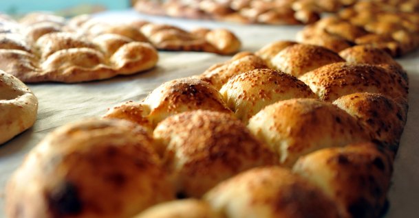Several special round baked flatbread referred to as the Ramazan pide, made from an oven-baked enriched dough and sprinkled with nigella and sesame seeds on top, sit on a counter in Tokat, Turkey, April 13, 2021. (AA Photo)