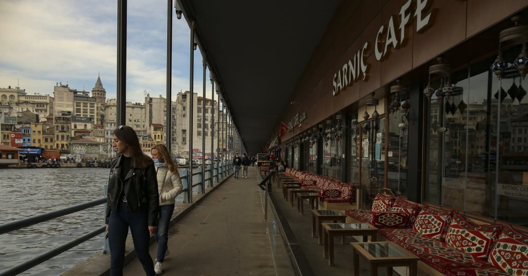 People walk past a cafe inside Galata Bridge, in Istanbul, Turkey, April 13, 2021. (AP Photo)
