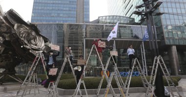 South Korean peace activists on the ladders stage a rally supporting Myanmar's democracy, outside the POSCO office in Seoul, South Korea on Feb. 22, 2021. (AP Photo)