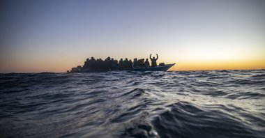 Migrants and refugees from different African nationalities wait for assistance aboard an overcrowded wooden boat, as aid workers of the Spanish NGO Open Arms approach them in the Mediterranean Sea, international waters, at 122 miles off the Libyan coast, Feb. 12, 2021. (AP Photo)
