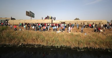 People gather at the site where train carriages derailed in Qalyubia province, north of Cairo, Egypt, April 18, 2021. (Reuters Photo)
