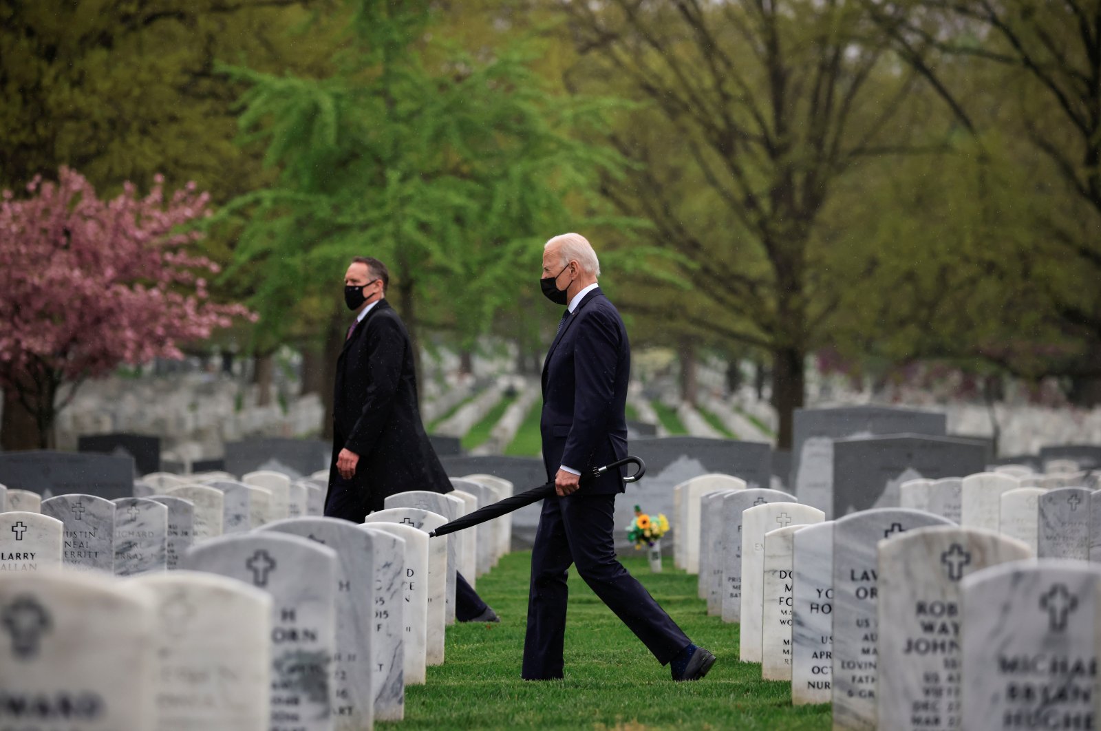 U.S. President Joe Biden carries an umbrella as he walks among graves in a visit to pay his respects to fallen veterans of the Afghan conflict, in Arlington National Cemetery in Arlington, Virginia, U.S., April 14, 2021. (Reuters Photo)