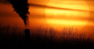 Emissions from a coal-fired power plant are silhouetted against the setting sun in Independence, Missouri, U.S., Feb. 1, 2021. (AP Photo)