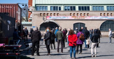 People wait in line to get their vaccines against Covid-19 outside a nightclub turned mass vaccination center in Stockholm, Sweden, on April 16, 2021, amid the  COVID-19 pandemic. (AFP) 
