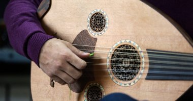 Iranian master player and instructor Hamid Khansari tests a new instrument at luthier Fatemeh Moussavi's (unseen) oud-making workshop in the capital Tehran, Iran, Dec. 14, 2020. (AFP Photo)