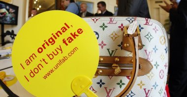 A counterfeit Louis Vuitton luxury handbag is displayed by French customs officers before a destruction operation in Cannes, France, Sept. 28, 2009. (Reuters)