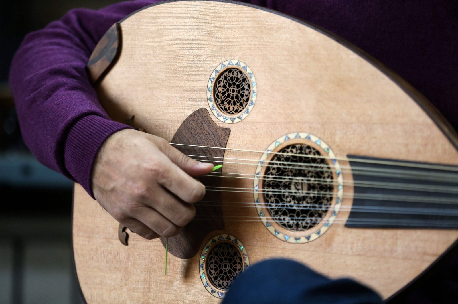 Iranian master player and instructor Hamid Khansari tests a new instrument at luthier Fatemeh Moussavi's (unseen) oud-making workshop in the capital Tehran, Iran, Dec. 14, 2020. (AFP Photo)