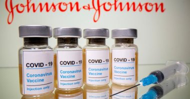 Vials with a sticker reading, "COVID-19 / Coronavirus vaccine / Injection only" are seen in front of the Johnson & Johnson logo, October 31, 2020. (REUTERS Photo)