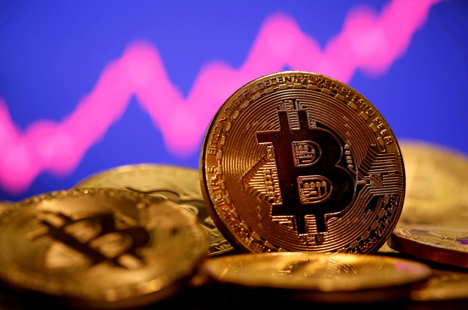 A representation of virtual currency Bitcoin is seen in front of a stock graph in this illustration taken Jan. 8, 2021. (Reuters Photo)
