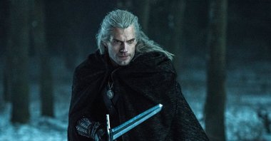 Actor Henry Cavill portrays “Geralt of Rivia”, wielding a sword in a forest covered with snow, in a scene from the Netflix TV series "The Witcher," based on a fantasy novel series that found fame as a video game. (Netflix via AP)