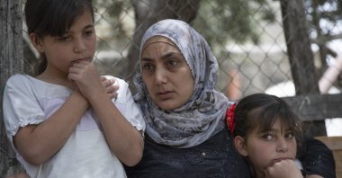 Somaya, the wife of Palestinian Osama Mansour, who was shot to death by Israeli soldiers at a temporary checkpoint in the occupied West Bank earlier this month, holds their 10 year-old twins Nissan, left and Bissan, right, at their family house, in the West Bank village of Biddu, west of Ramallah, Tuesday, April 20, 2021. (AP Photo)