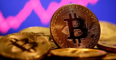 A representation of the virtual currency Bitcoin is seen in front of a stock graph in this illustration, Jan. 8, 2021. (Reuters Photo)