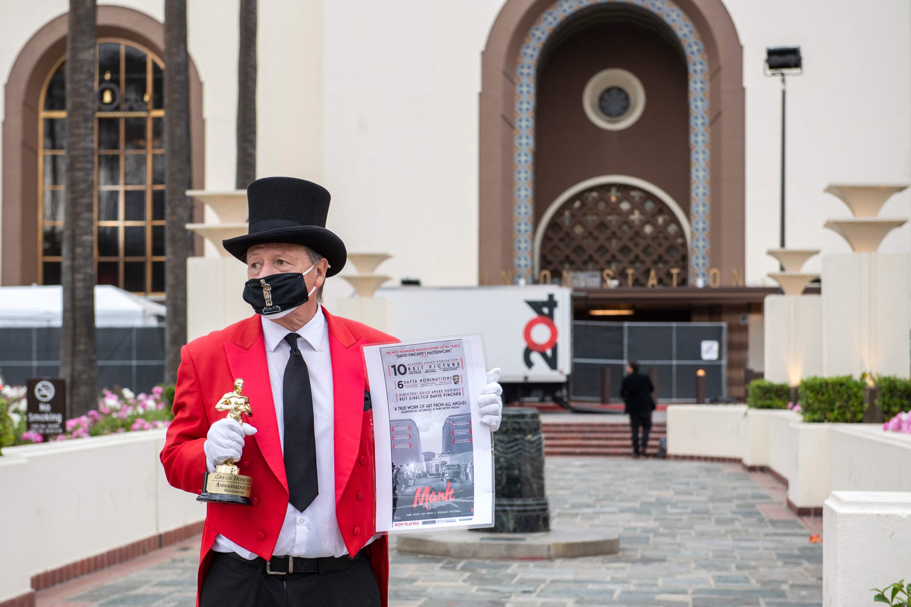 Gregg Donovan holds a fake Oscar statuette and a 'Mank' poster, during preparations for the 93rd Academy Awards, in front of Union Station in Los Angeles, California, U.S., April 23, 2021. (AFP Photo)