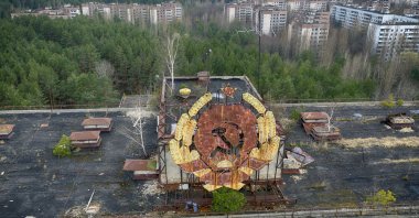 The rusty emblem of the Soviet Union is seen over the ghost town of Pripyat close to the Chernobyl nuclear plant, Ukraine, April 15, 2021. (AP Photo)