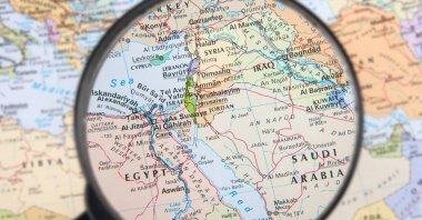 In this illustration photo, a magnifying glass provides a partial view of the Middle East. (Photo by Shutterstock)