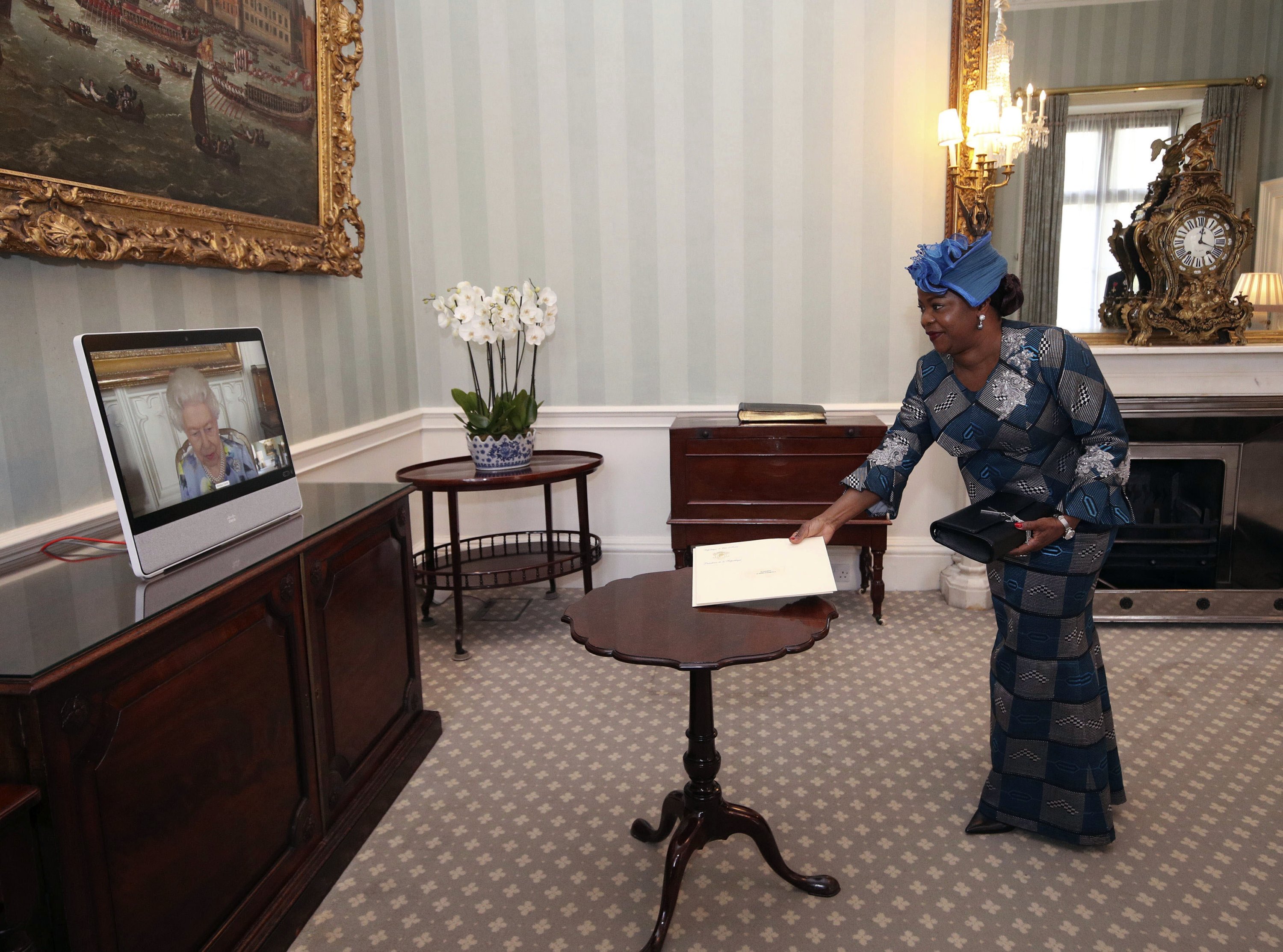 Britain's Queen Elizabeth II appears on a screen by videolink from Windsor Castle, during a virtual audience to receive Her Excellency Sara Affoue Amani, the Ambassador of Cote d'Ivoire, at Buckingham Palace, London, U.K., April 27, 2021. (AP Photo)