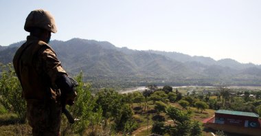 A Pakistani Army soldier stands near a house that was damaged in cross border shelling before the cease-fire, in Salohi village, Poonch district near the Line of Control, Pakistani administered Kashmir, April 26, 2021. (EPA Photo)