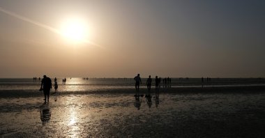 Residents enjoy the sunrise after starting their fast during the holy month of Ramadan at Ramlet al-Baida beach on Tarout Island, Saudi Arabia, April 23, 2021. (Reuters Photo)
