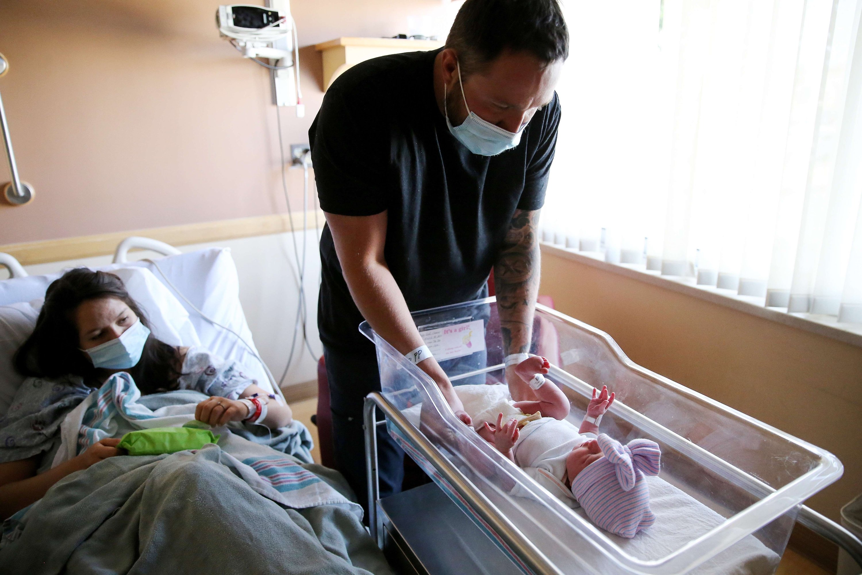 Matthew Karnes bersiap untuk mengganti popok putrinya yang baru lahir, Evelina Karnes, sementara istrinya Brianna Lamas mengamati unit pasca melahirkan di Providence Saint Mary's Medical Center di Apple Valley, California, AS, 30 Maret 2021 (Getty Images / AFP)