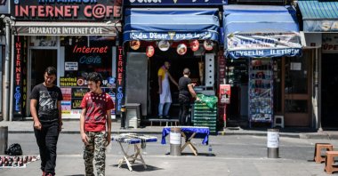 Syrian men walk pass a Syrian fast food restaurant in the Fatih district of Istanbul, Turkey, July 4, 2016. (AFP Photo)