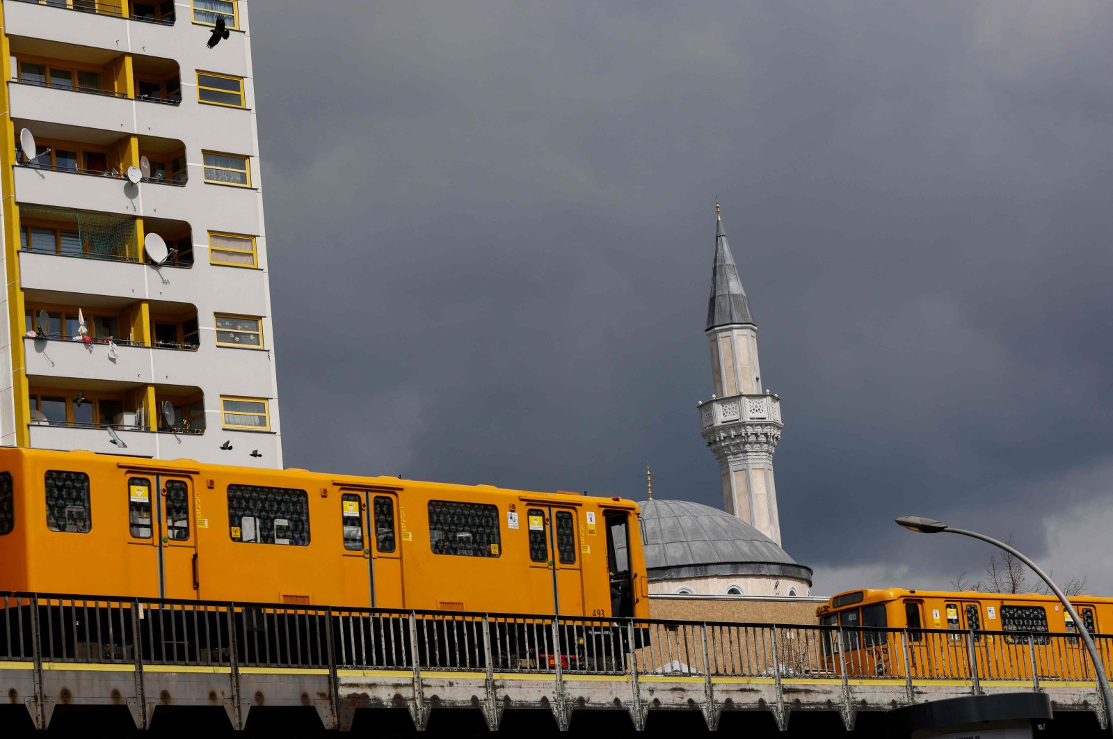 Two U-bahn subway trains drive past the Mevlana Mosque in Berlin's Kreuzberg district on April 14, 2021, a day after the start the Muslim holy fasting month of Ramadan. (Photo by David GANNON / AFP)