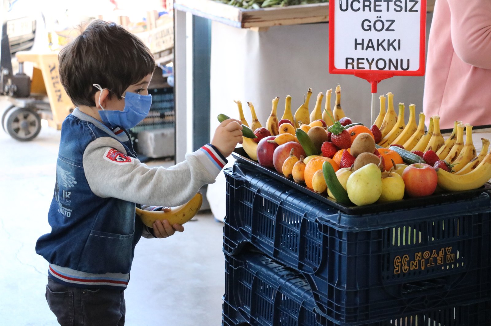 A child picks a piece of fruit from a stand offering free produce, in Afyon, western Turkey, April 29, 2021. (DHA PHOTO)