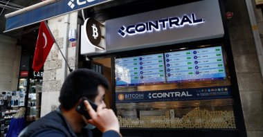 A man talks on his mobile phone as he walks past a cryptocurrency exchange shop in Istanbul, Turkey, April 27, 2021. (Reuters Photo)