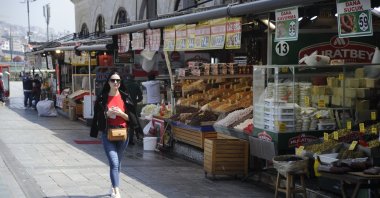 A woman passes by stores in the historic Eminönü neighborhood on the city's European side, Istanbul, Turkey, April 30, 2021. (IHA Photo)