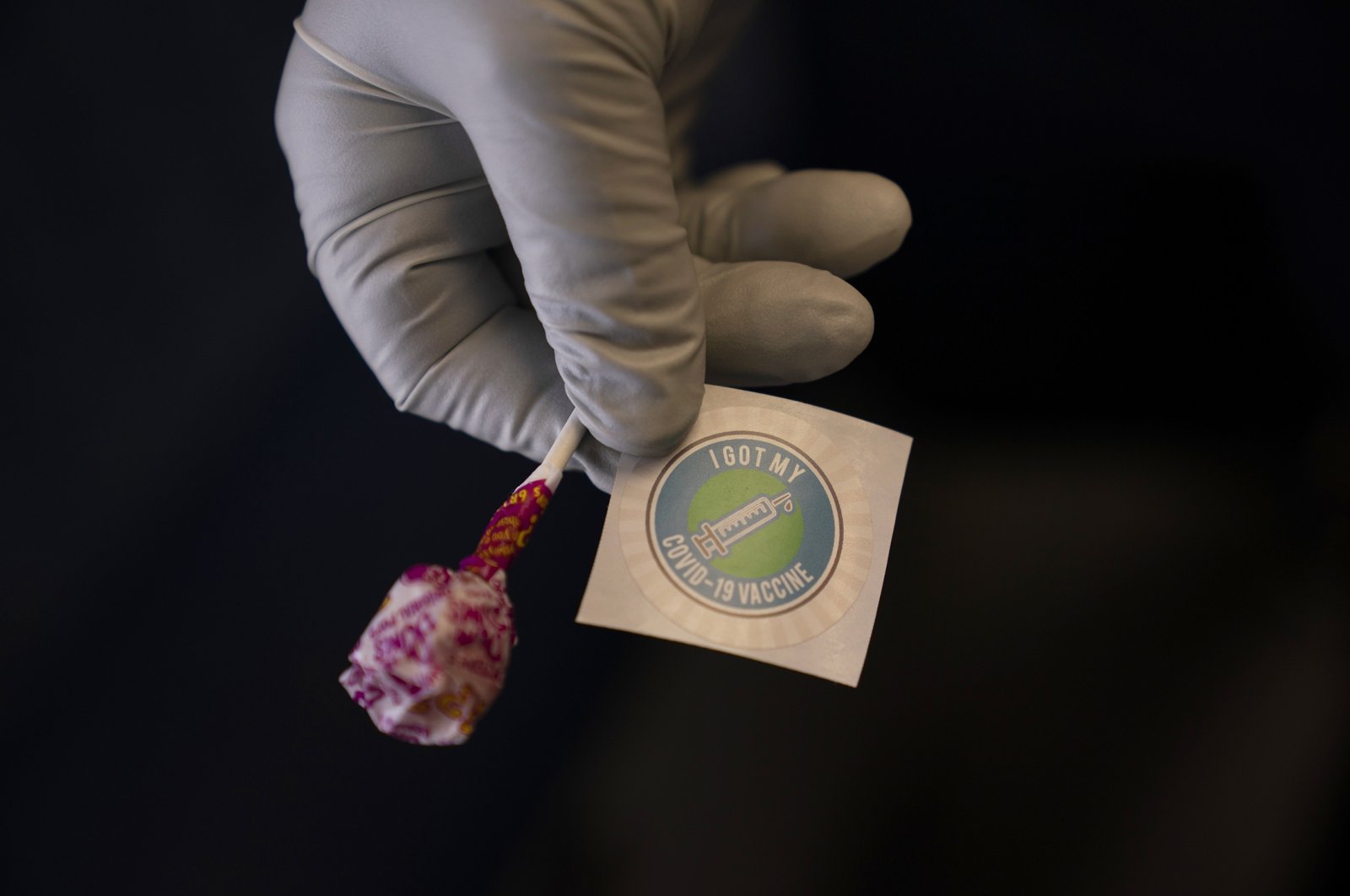 A nurse prepares a lollipop and an "I Got My COVID-19 Vaccine" sticker for a recipient in a mobile clinic set up in the parking lot of a shopping center in Orange, California, U.S., April 29, 2021.  (AP Photo)