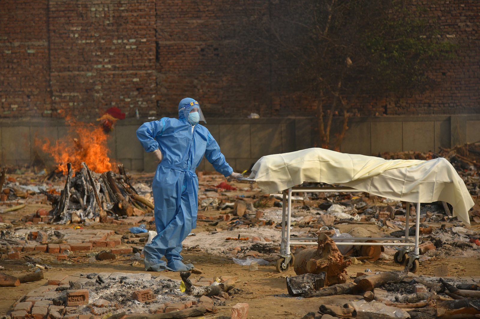A family member wearing personal protective equipment (PPE) waits to perform the last rites for a COVID-19 victim at a cremation ground in New Delhi, India, April 29, 2021. (EPA Photo)