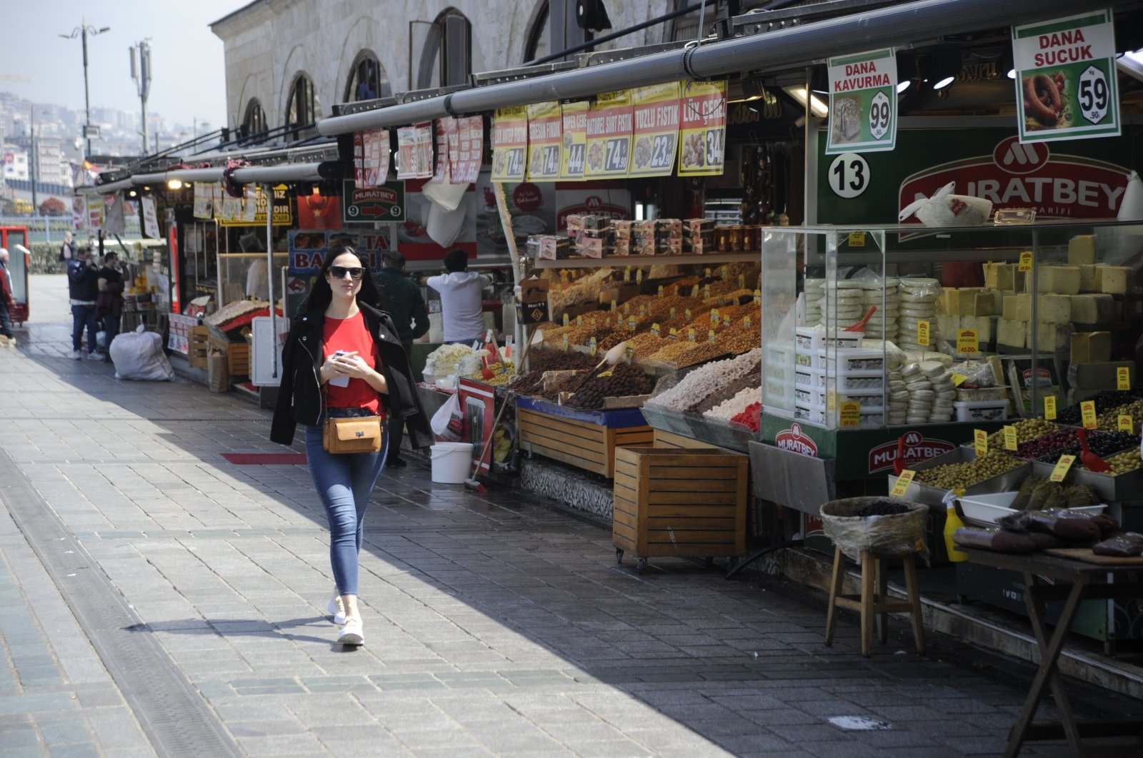 A woman passes by stores in the historic Eminönü neighborhood on the city's European side, Istanbul, Turkey, April 30, 2021. (IHA Photo)