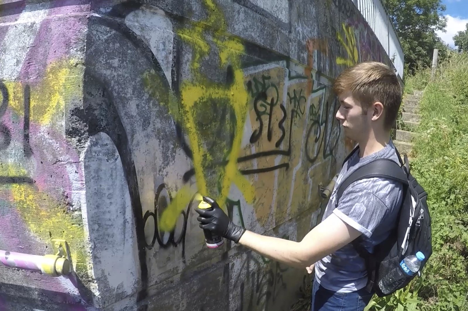 This grab taken from a video provided by the Metropolitan Police shows Benjamin Hannam spray painting graffiti which was shown to the jury during his trial at the Old Bailey in London, the U.K., Thursday, April 1, 2021. (Metropolitan Police via AP)