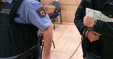 The accused (R) is led by a judicial officer into the hall of the Higher Regional Court, Koblenz, Germany, Feb. 27, 2020. (Getty Images)