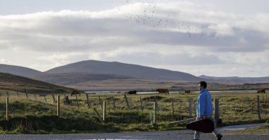 In this image made from video provided by Focus Features, Amir El-Masry who stars as "Omar" in the film "Limbo" walks along a road on the Uist islands, in the Outer Hebrides, Scotland. (Focus Features via AP)