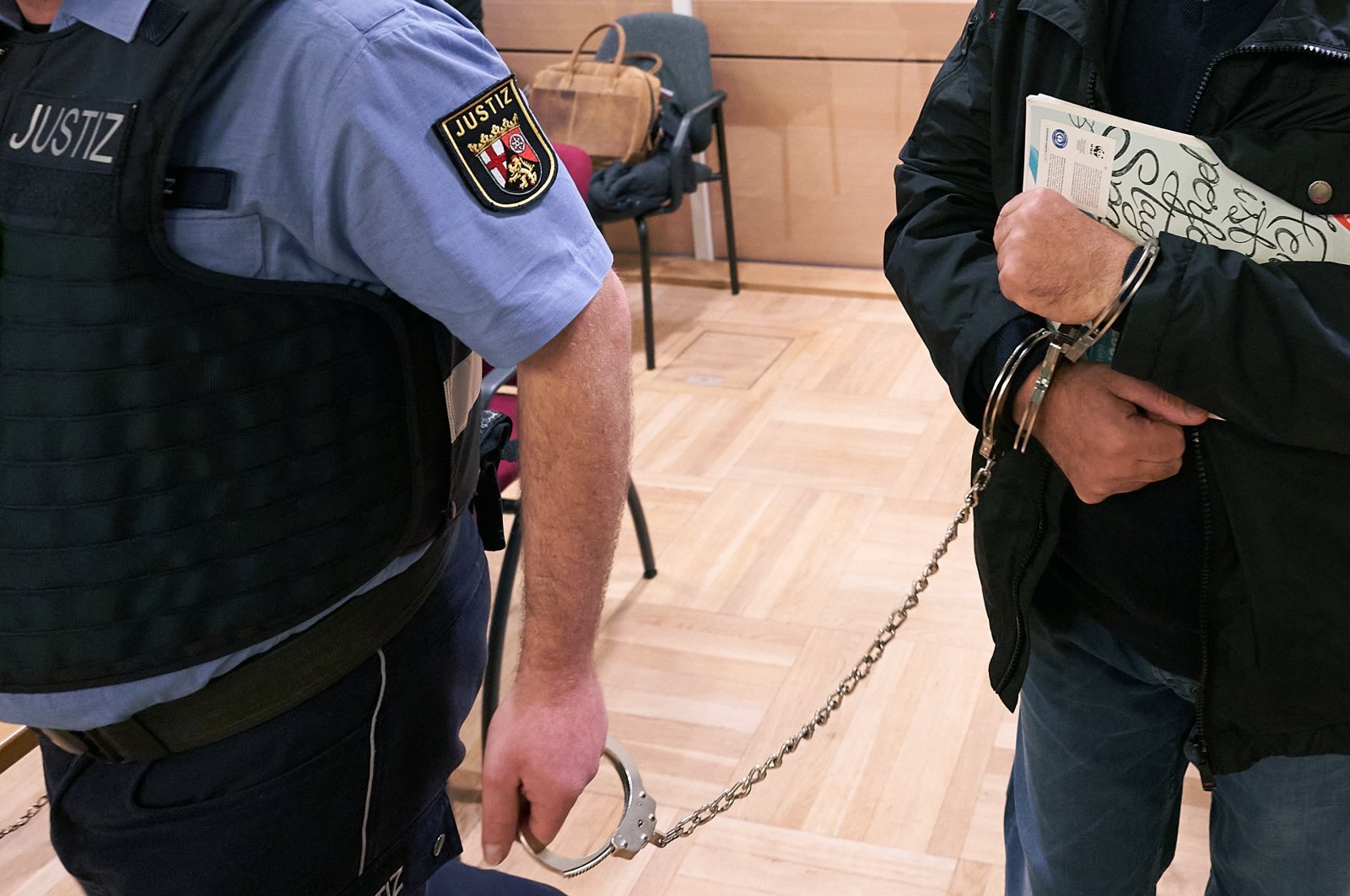 The accused (R) is led by a judicial officer into the hall of the Higher Regional Court, Koblenz, Germany, Feb. 27, 2020. (Getty Images)