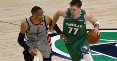 Dallas Mavericks guard Luka Doncic (R) handles the ball as Washington Wizards guard Russell Westbrook tries to slow him down during an NBA game, Dallas, U.S., May 1, 2021. (AP Photo)
