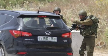 Israeli soldiers search cars at the Hawara checkpoint, the southern entrance to Nablus city in the illegally occupied West Bank, on May 3, 2021 (AFP Photo)