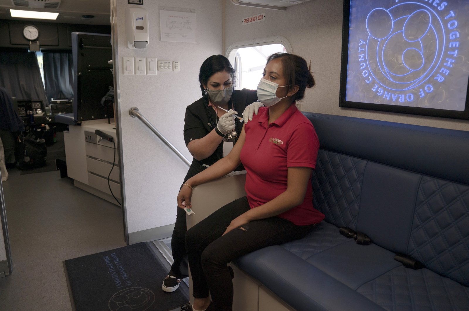 A nurse administers a dose of the Moderna COVID-19 vaccine to a woman in a mobile clinic set up in the parking lot of a shopping center in Orange, California, U.S., April 29, 2021. (AP Photo)