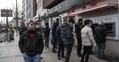 Customers wait in line to use the ATMs of a Turkish bank near the Grand Bazaar in Istanbul, Turkey, March 22, 2021. (AFP Photo)