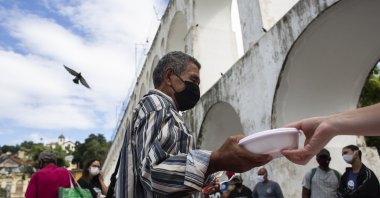 People line up for free meals delivered by Covid Without Hunger group of volunteers, in Rio de Janeiro, Brazil, Apr. 29, 2021. (AP PHOTO) 
